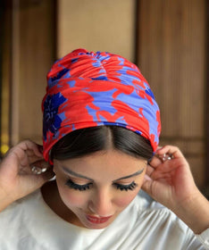 A woman wearing a turban with a red and blue print, showcasing cultural diversity and vibrant colors.
