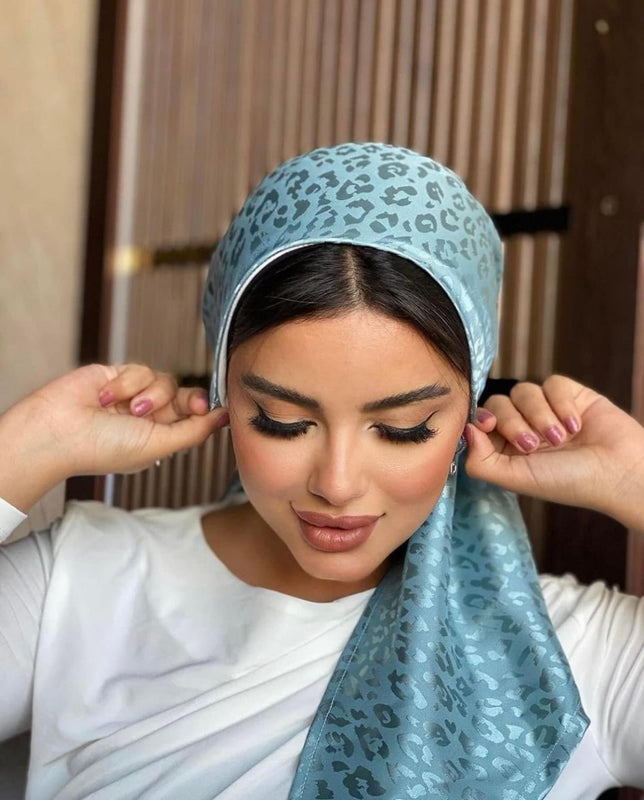 A woman with a blue headscarf, looking serene and elegant.