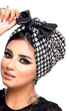 An elegant lady with a black and white checkered head wrap, showcasing her fashion sense.