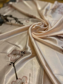 Pink silk fabric with cherry blossom design, perfect for elegant clothing or home decor.